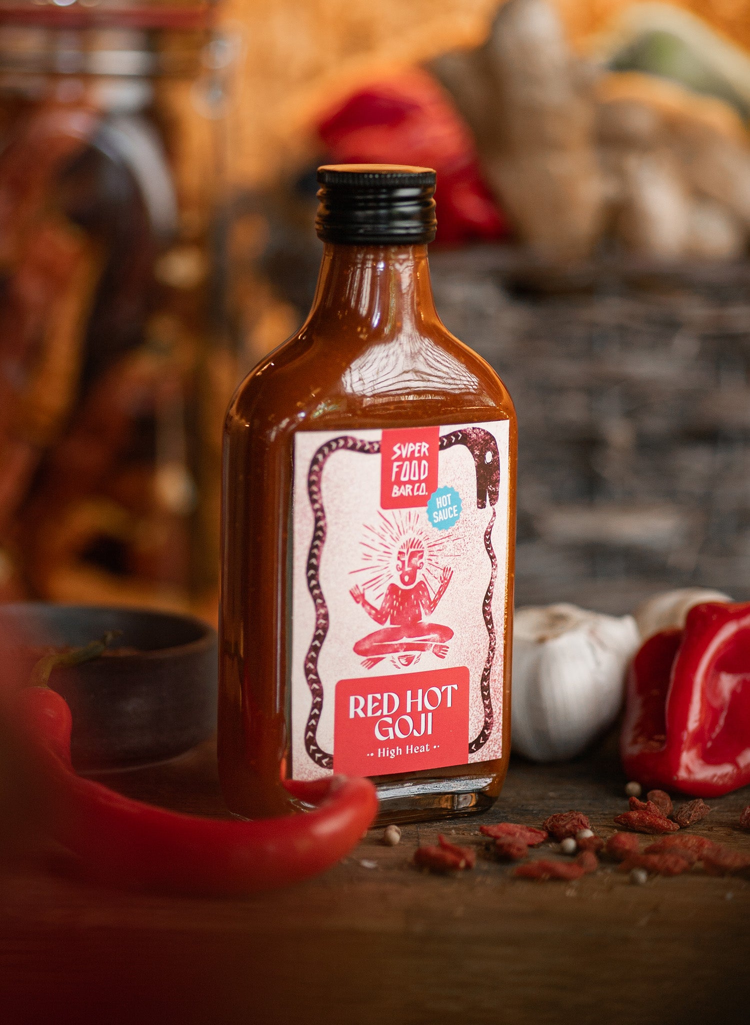 Fermented Red Hot Goji hot sauce bottle on a table with fresh ingredients