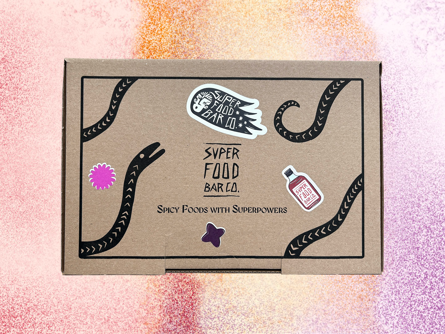 Closed Superfood Bar Co. gift box with graphic label design and product stickers, shown on a colorful  background

