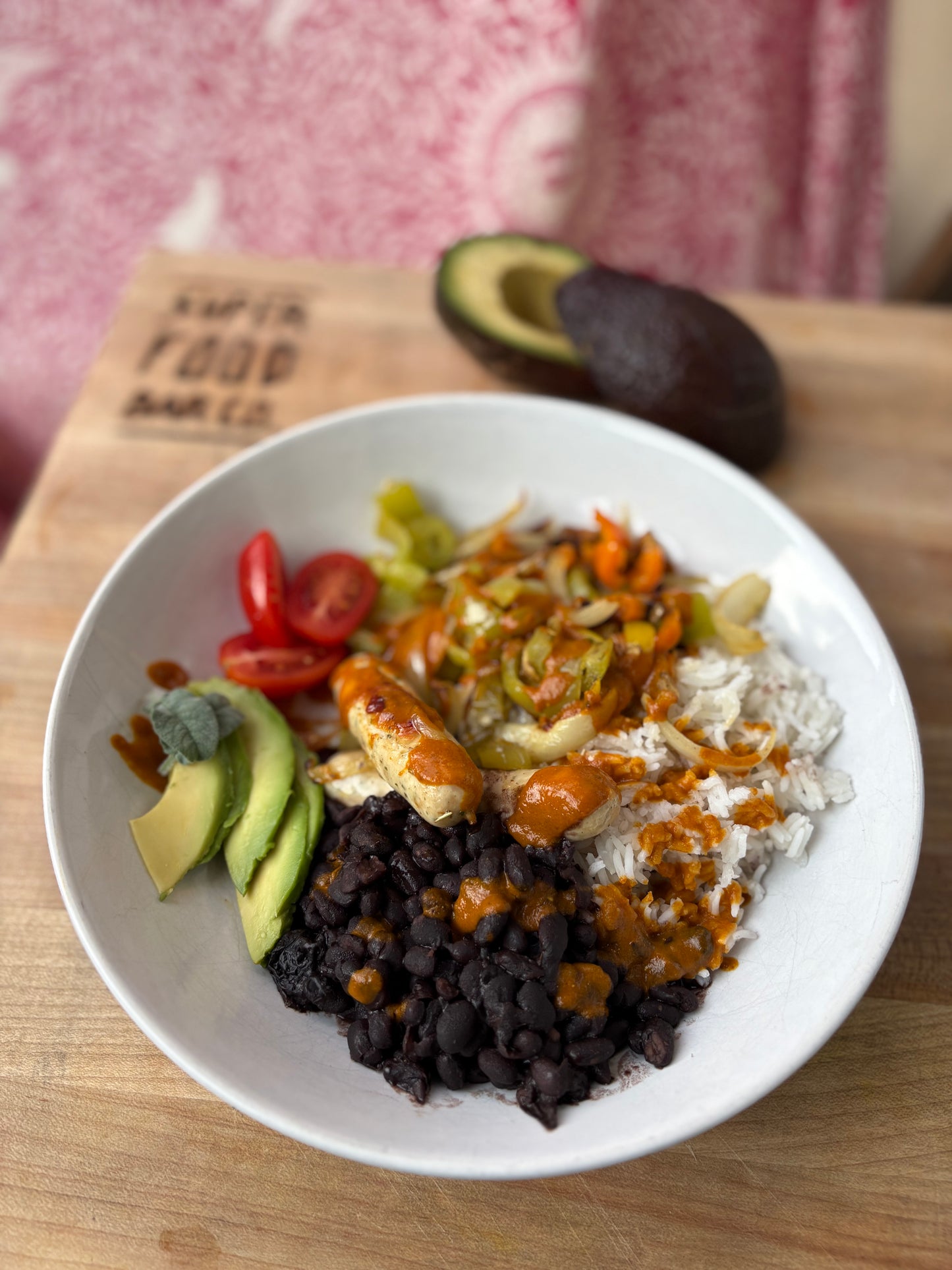 Vegan rice dish with Golden Mango hot sauce, avocado, black beans, and sausage